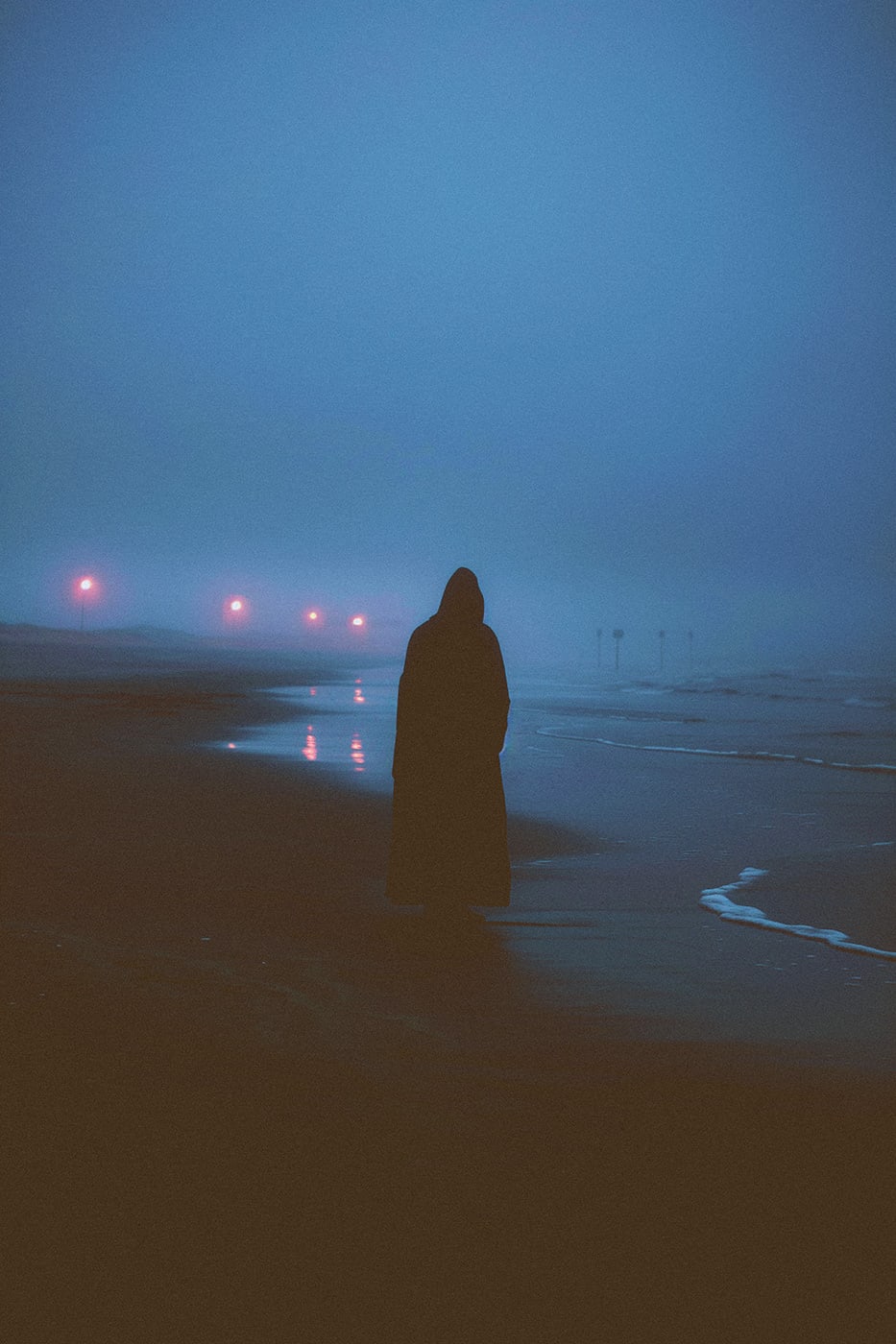 A lone hooded person at an empty evening beach, waves crashing quietly on the shores. An ethereal, minimalist new media AI artwork on the beauty and magic of loneliness, inspired by the cinematic look of Blade Runner 2049. | Wall Art